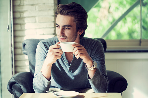 Young man drinking coffee in cafe