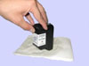 A hand's setting cartridge print head down onto a damp paper towel